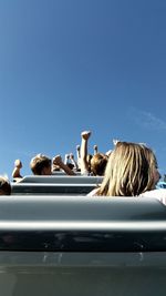 People on shore against clear sky