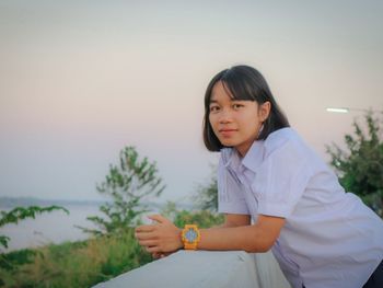 Portrait of woman sitting against sky