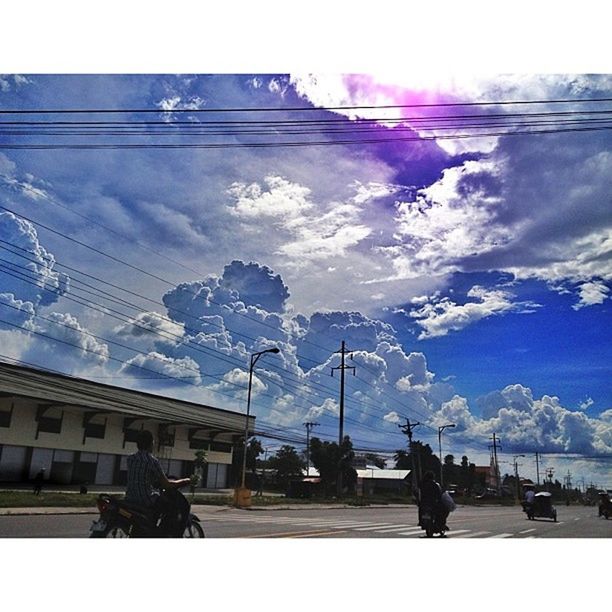 sky, weather, building exterior, built structure, power line, architecture, cloud - sky, snow, cold temperature, winter, transportation, electricity pylon, men, season, cable, day, cloud, car, mode of transport