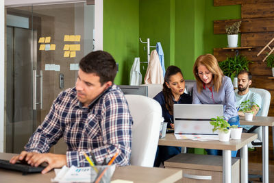 Female friends using digital tablet in office