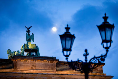 Low angle view of illuminated statue against sky