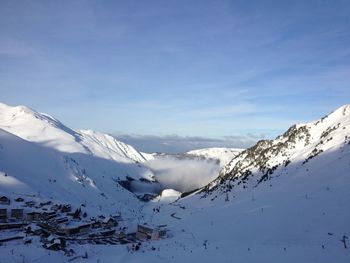 Scenic view of mountain range against cloudy sky