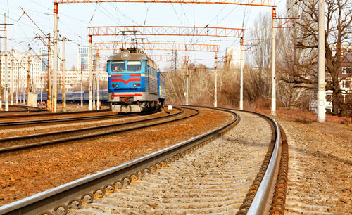 Train on railroad tracks in city against sky