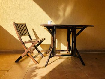 Minimalistic shot of wooden chair and table sitting in the bright sunlight