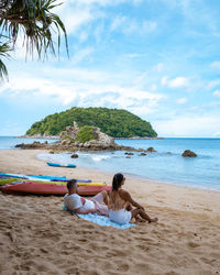 Rear view of women sitting on beach