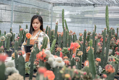 Full length of woman standing in greenhouse