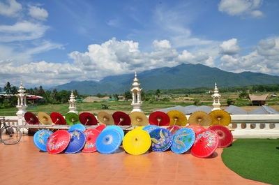 Multi colored umbrella on table by building against sky