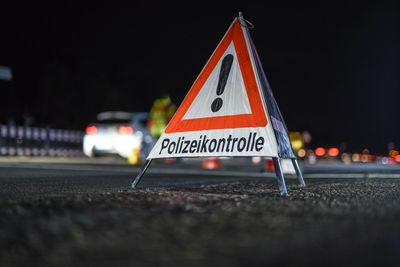 Close-up of information sign on road at night