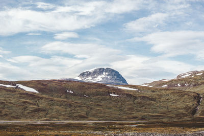 Scenic view of mountains against cloudy sky