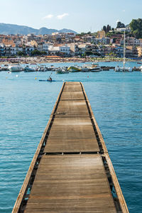 Pier over sea against sky in city