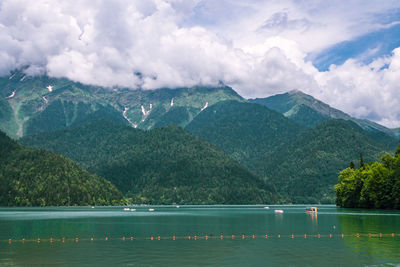 Scenic view of lake by mountains against sky