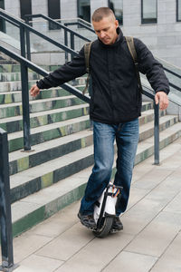 Man riding fast on electric unicycle on city street. mobile portable individual transportation