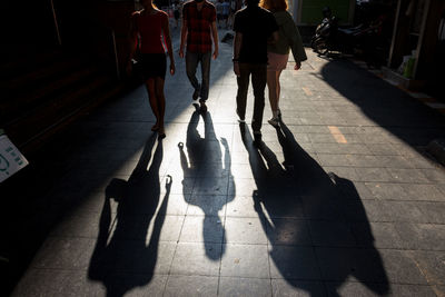 Low section of people standing on zebra crossing in city