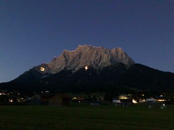 Scenic view of illuminated mountains against clear sky at night