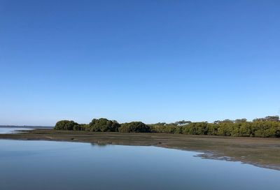 Scenic view of lake against clear blue sky