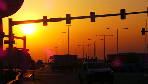 Cars on illuminated city during sunset