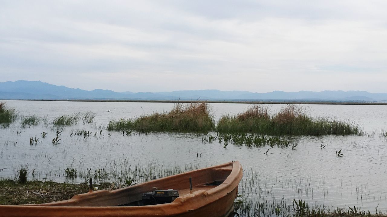 transportation, nautical vessel, boat, mode of transport, water, sky, moored, tranquil scene, mountain, lake, tranquility, scenics, nature, beauty in nature, travel, mountain range, cloud - sky, river, tree, sea