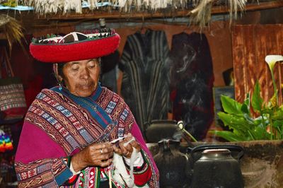 Woman in traditional clothing working at shop