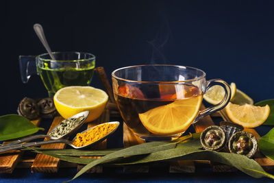 Cup of tea with a slice of lemon with eucalyptus, lemons and spices