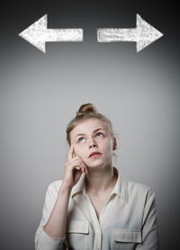 Portrait of young woman standing against white background