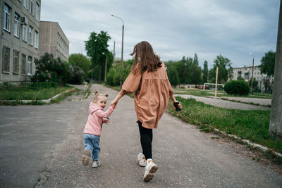 Mom with toddler daughter running on the track outdoors