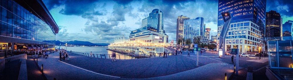 Panoramic shot of illuminated city against blue sky