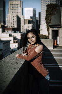 Portrait of young woman standing on city street