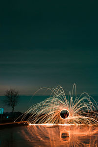 Wire wool by water against sky at night