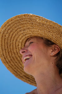 Portrait of mid aged woman with short hair wearing straw hat smiling