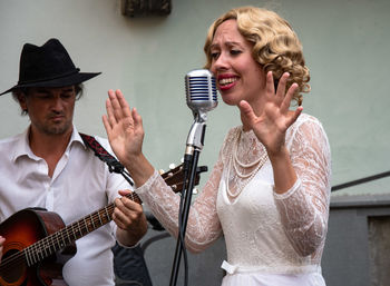 Woman singing by man playing guitar