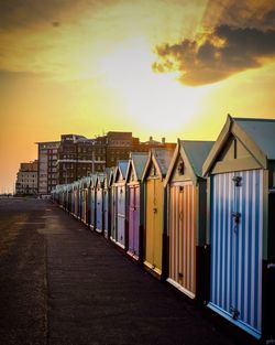 Beach huts and buildings against sky during sunset