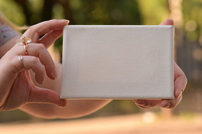 Cropped hands of woman holding blank box