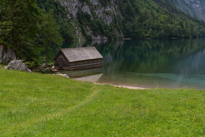 Wooden oat house by a peaceful lake scene and green grass