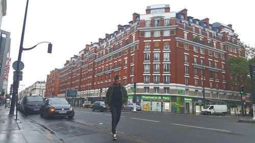 Rear view of man walking on street in city