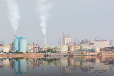Smoke emitting from factory against sky