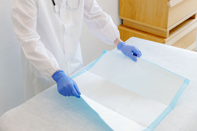 Midsection of doctor holding dentures