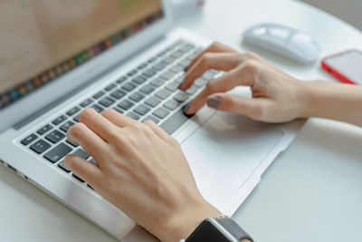 Midsection of person using laptop on table