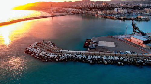 High angle view of city by sea against sky