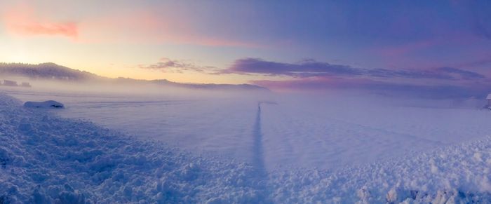 Scenic view of snow covered mountains against sky during sunset