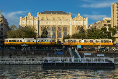 2 trams are stay in front of the vigado concert hall, budapest, hungary