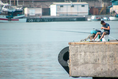 Man sitting on boat against sea