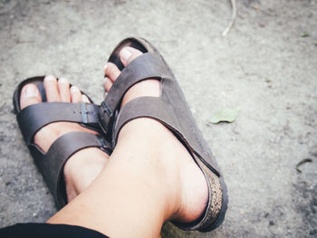 Low section of woman wearing shoes on street