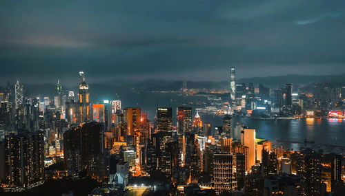 Illuminated buildings in city against sky at night