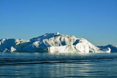 Scenic view of frozen sea against clear blue sky