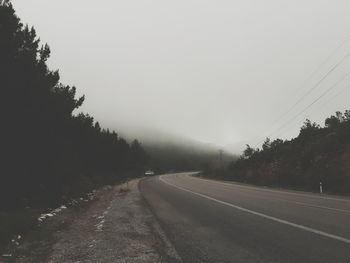 Road amidst trees against sky