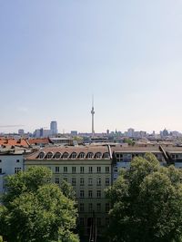 Buildings in city against clear sky
