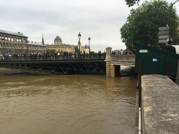 Bridge over river against cloudy sky