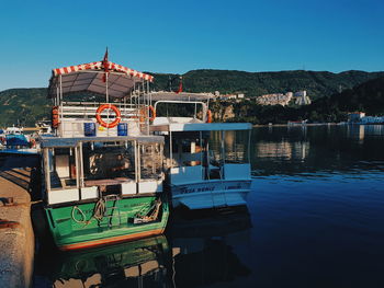 Boats in lake against clear blue sky