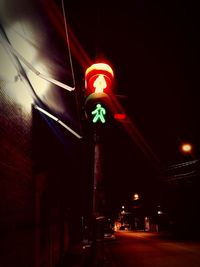 Low angle view of illuminated road signal at night