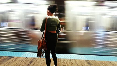 Full length of young woman standing by railing